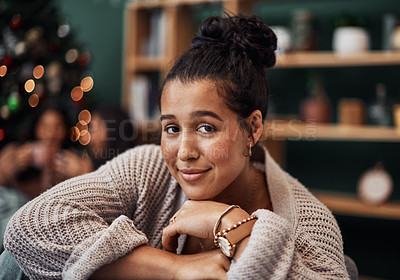Buy stock photo Shot of a beautiful young woman relaxing on the sofa with her friends in the background during Christmas at home