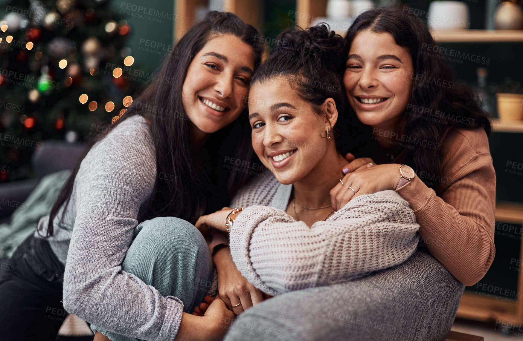 Buy stock photo Shot of young sisters relaxing on the sofa together during Christmas at home