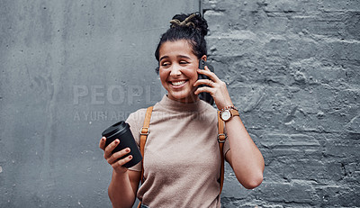 Buy stock photo Cropped shot of an attractive teenage girl standing alone and using her cellphone while holding a cup of coffee