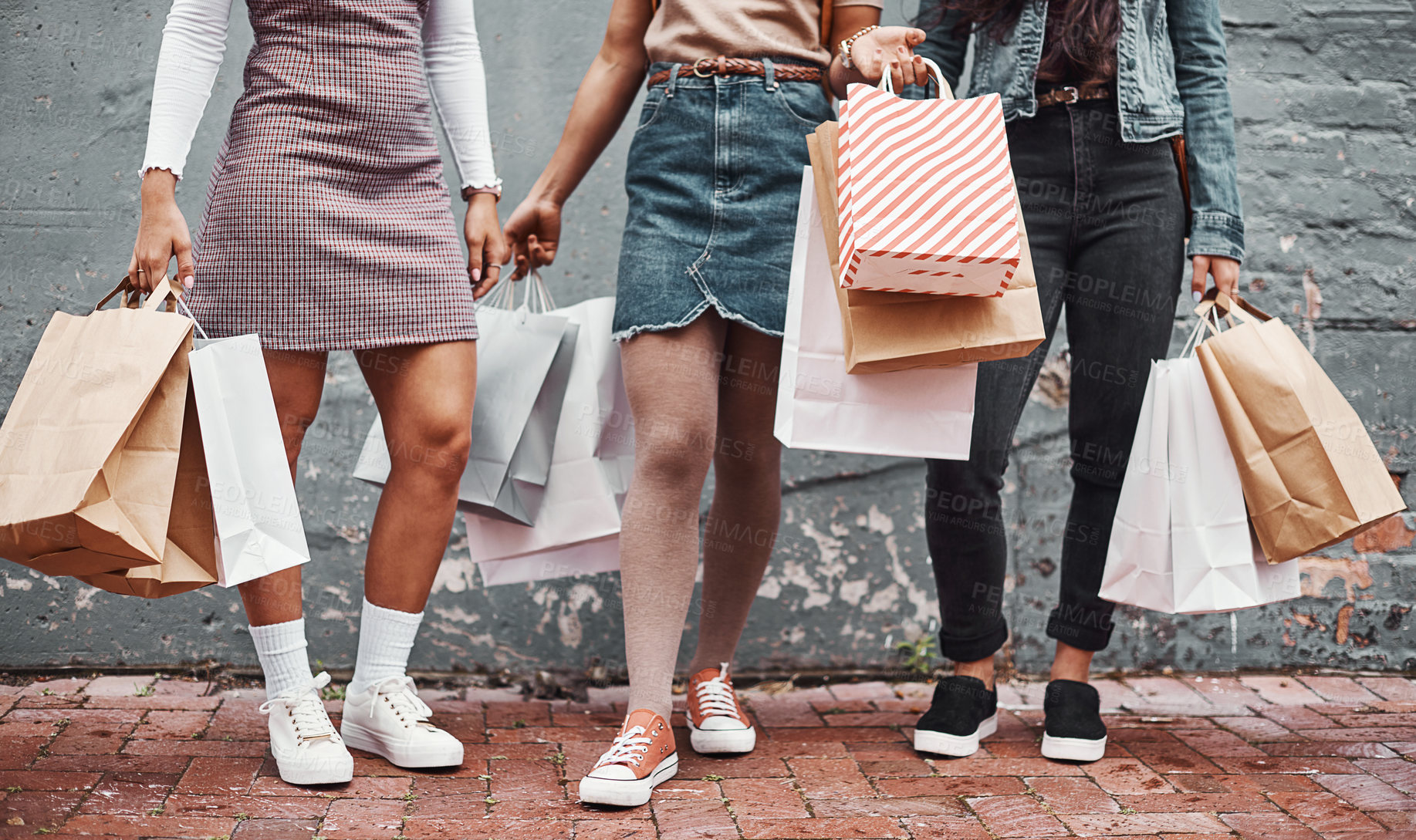 Buy stock photo Cropped shot of an unrecognizable group of sisters standing together with their shopping bags during a day in the city