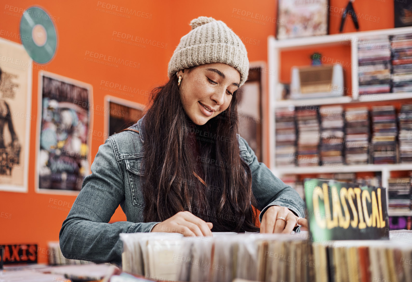 Buy stock photo Cropped shot of an attractive teenage girl standing alone and shopping for vinyl music records in the city