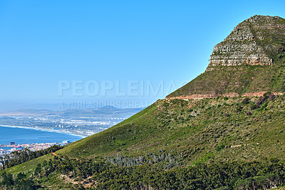 Buy stock photo Landscape of Lions Head mountain on a clear blue sky with copy space. Mountain peak with rolling hills and the ocean in a green environment. Popular tourism hiking location in Cape Town, South Africa