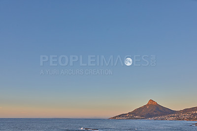 Buy stock photo Ocean landscape with a mountain on the coastline at sunset in South Africa. Scenic nature landscape of Lions Head at dawn near a calm peaceful sea against a blue horizon with copy space in Cape Town