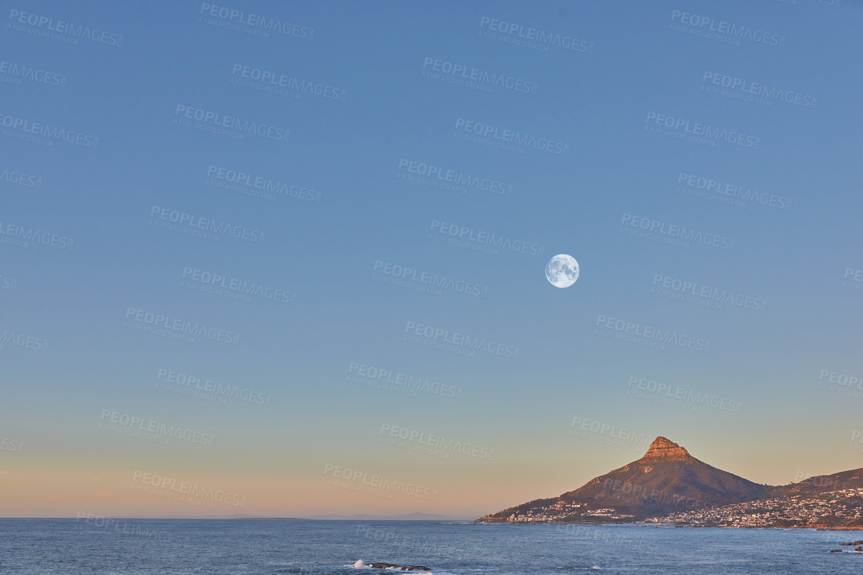 Buy stock photo Ocean landscape with a mountain on the coastline at sunset in South Africa. Scenic nature landscape of Lions Head at dawn near a calm peaceful sea against a blue horizon with copy space in Cape Town