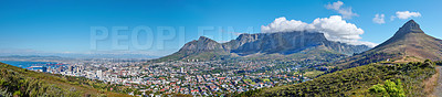 Buy stock photo Panoramic landscape of Table mountain and surrounding urban town and a scenic road for traveling along Cape Town, South Africa. A mountain road overlooking the city with a cloudy blue sky in summer