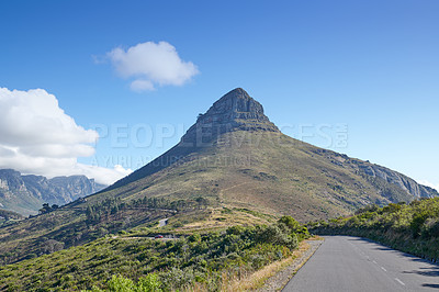 Buy stock photo A road leading to Lions Head in Cape Town, South Africa against blue sky copyspace on a sunny morning. A highway along a peaceful mountain landscape with scenic views or lush green bushes and trees