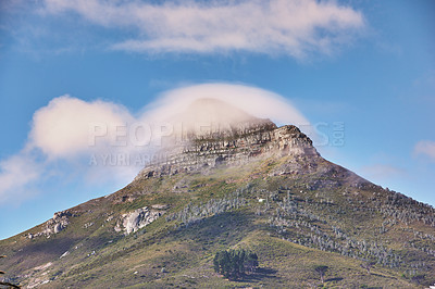 Buy stock photo Landscape view of Lions Head mountain with clouds covering the peak against a blue sky and copy space in Cape Town, South Africa. Wild, rough hiking terrain in popular tourism destination and nature