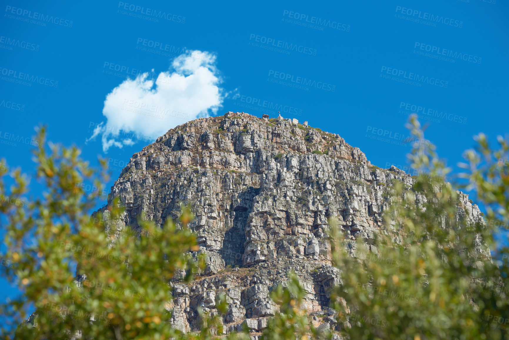 Buy stock photo Beautiful mountain with a cloudy blue sky background on a summer day. The landscape of a peak near lush green plants outdoors in nature on a spring afternoon with copy space