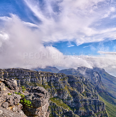 Buy stock photo Thick clouds forming on the top of Table Mountain in Cape Town with copyspace. Rocky terrain on a sunny day with cloudy shadows, peaceful nature in harmony with soothing views of plants and landscape