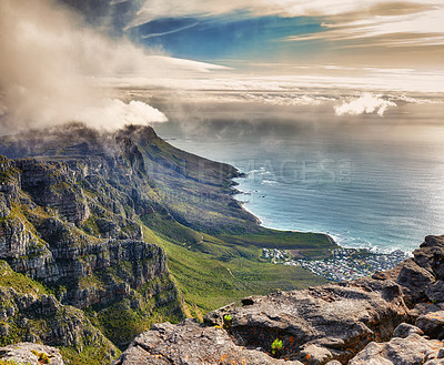 Buy stock photo Aerial view of clouds rolling over Table mountain in Cape town, South Africa with copyspace. Beautiful landscape of green bushes and rocky terrain on misty morning, calming view of the ocean and city