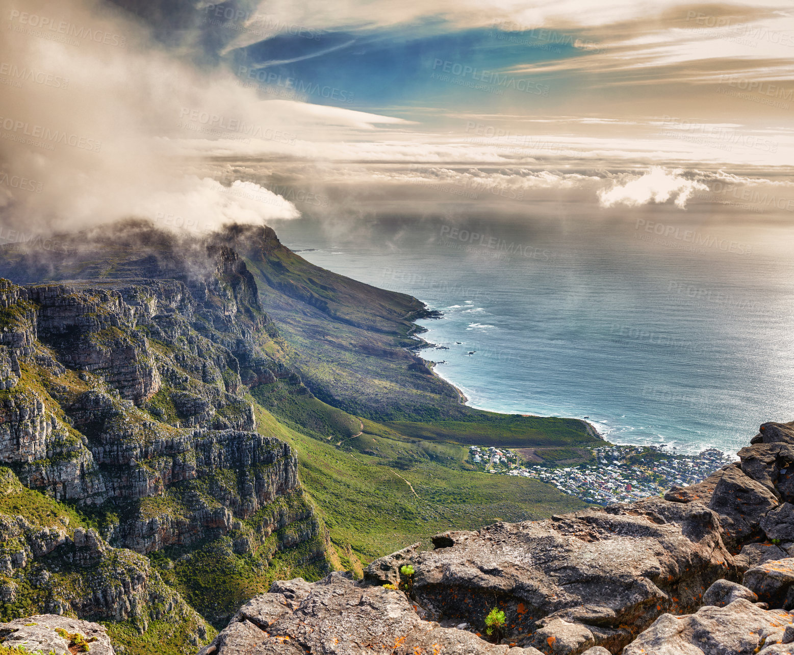 Buy stock photo Aerial view of clouds rolling over Table mountain in Cape town, South Africa with copyspace. Beautiful landscape of green bushes and rocky terrain on misty morning, calming view of the ocean and city