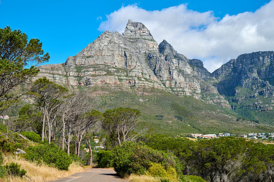 Buy stock photo Below view of a mountain peak in South Africa against a cloudy blue sky with copy space. Scenic nature landscape of a remote hiking and travel destination to explore near Table Mountain in Cape Town