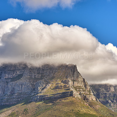 Buy stock photo Clouds covering top of Table Mountain, Cape Town with copyspace. Cloud shape and shadow over rocky terrain on a sunny day, beautiful, calm nature in harmony with scenic views of plants and landscape