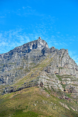 Buy stock photo Landscape of mountains and a blue sky with copy space. Rock outcrops of a mountain with wild green plants, bushes and vegetation in the popular location, Table Mountain, Cape Town in South Africa