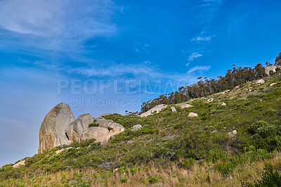 Buy stock photo Low angle view of Table Mountain in South Africa against a blue sky with copy space. Scenic nature landscape of a remote rocky hiking trail and travel location to explore in Cape Town