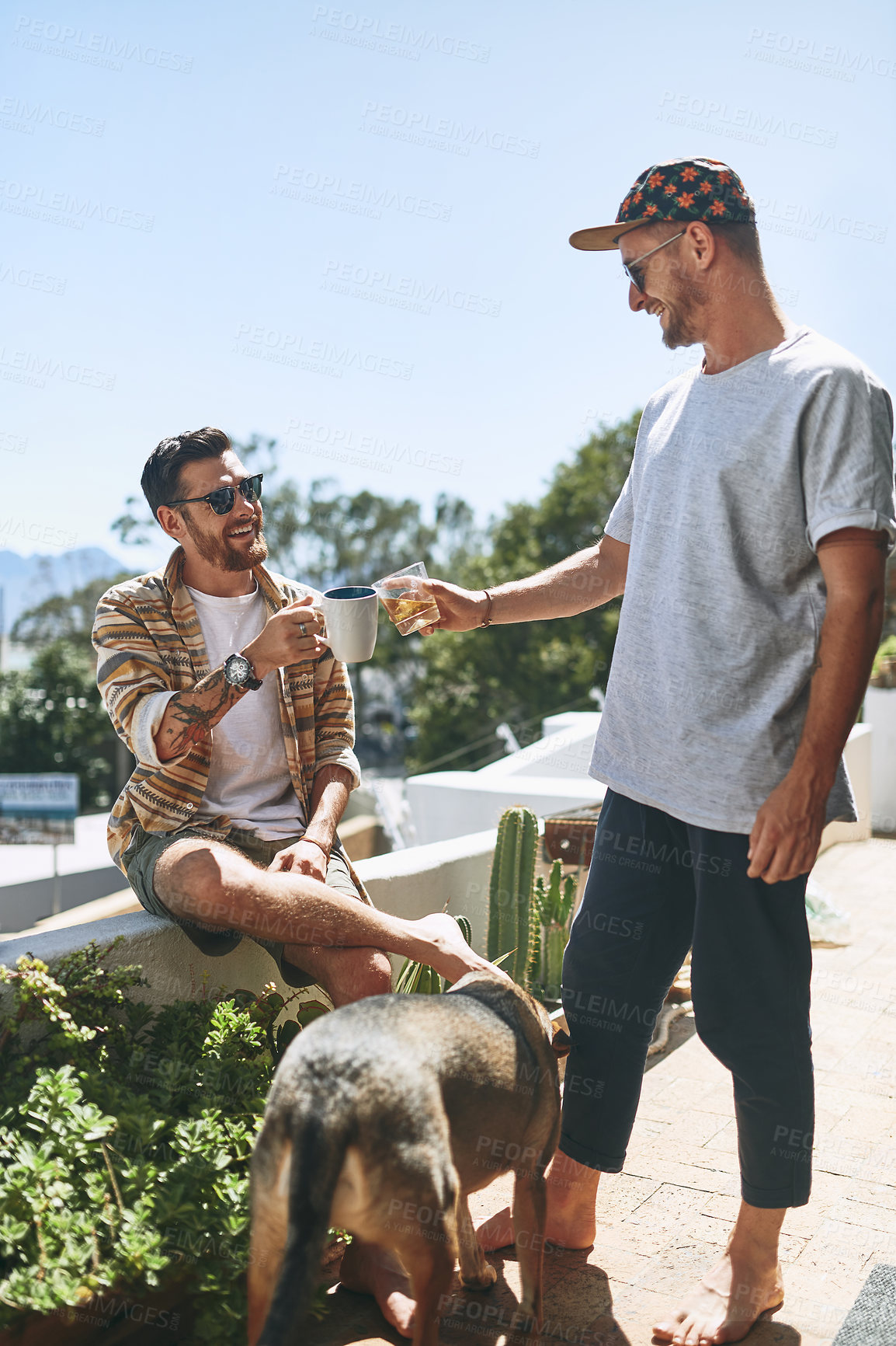 Buy stock photo Cropped shot of two cheerful young men hanging out outside on their balcony with their dog at home
