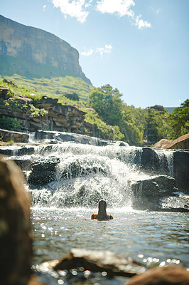 Buy stock photo Waterfall, mountain and back of woman swimming for adventure at travel destination, nature and outdoors. River, journey and person relax in water, dam and stream for holiday, vacation and tourism