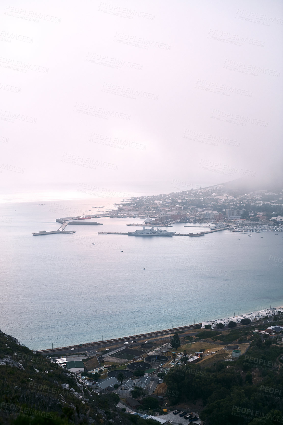 Buy stock photo Fog, ocean coast and buildings with harbor for natural scenery, urban settlement or beach view in nature. Cloudy sky, houses and roads with shoreline or dock of peaceful city, environment or seaside