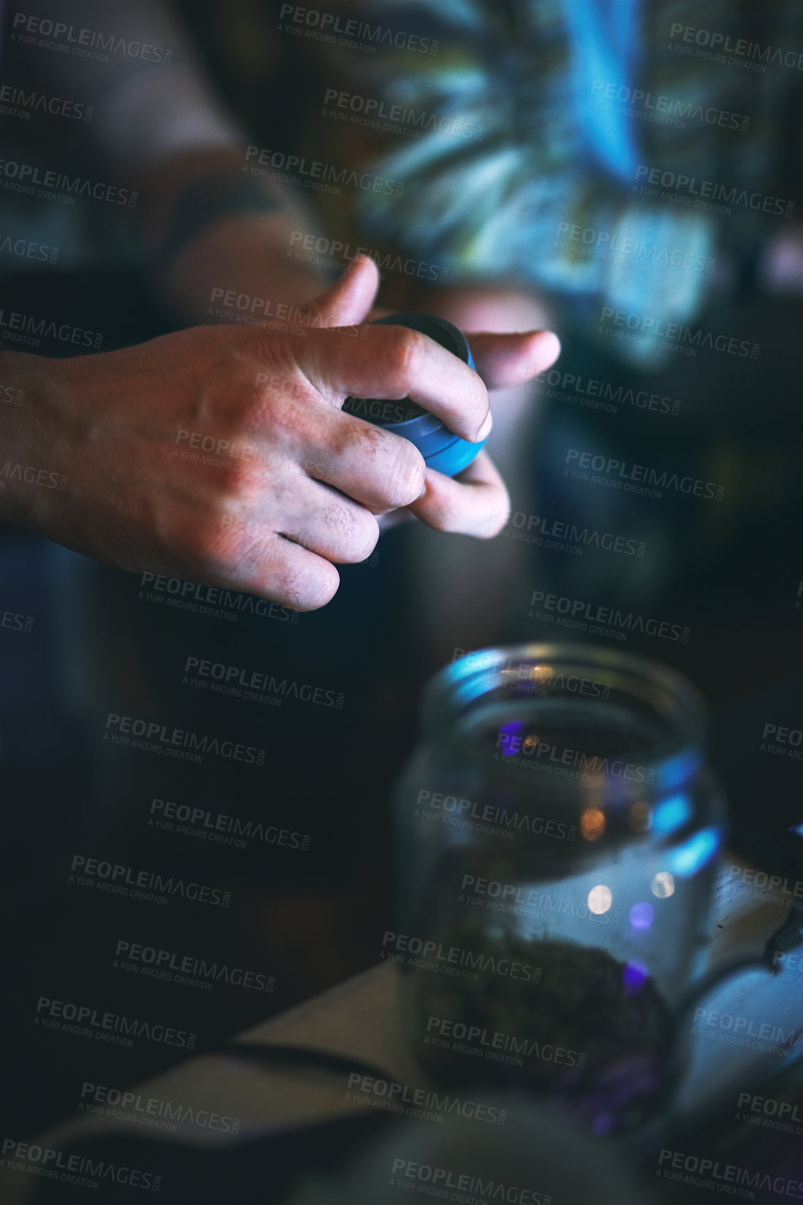 Buy stock photo Cropped shot of an unrecognizable man opening a tin of cannabis while sitting with his friend at home