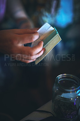 Buy stock photo Cropped shot of an unrecognizable man preparing to roll a joint of cannabis at home