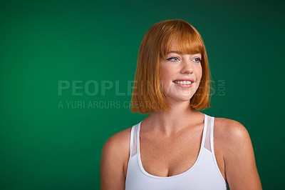 Buy stock photo Cropped shot of an attractive young sportswoman standing alone against a green background in the studio