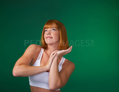 Buy stock photo Cropped shot of an attractive young sportswoman standing alone and posing against a green background in the studio