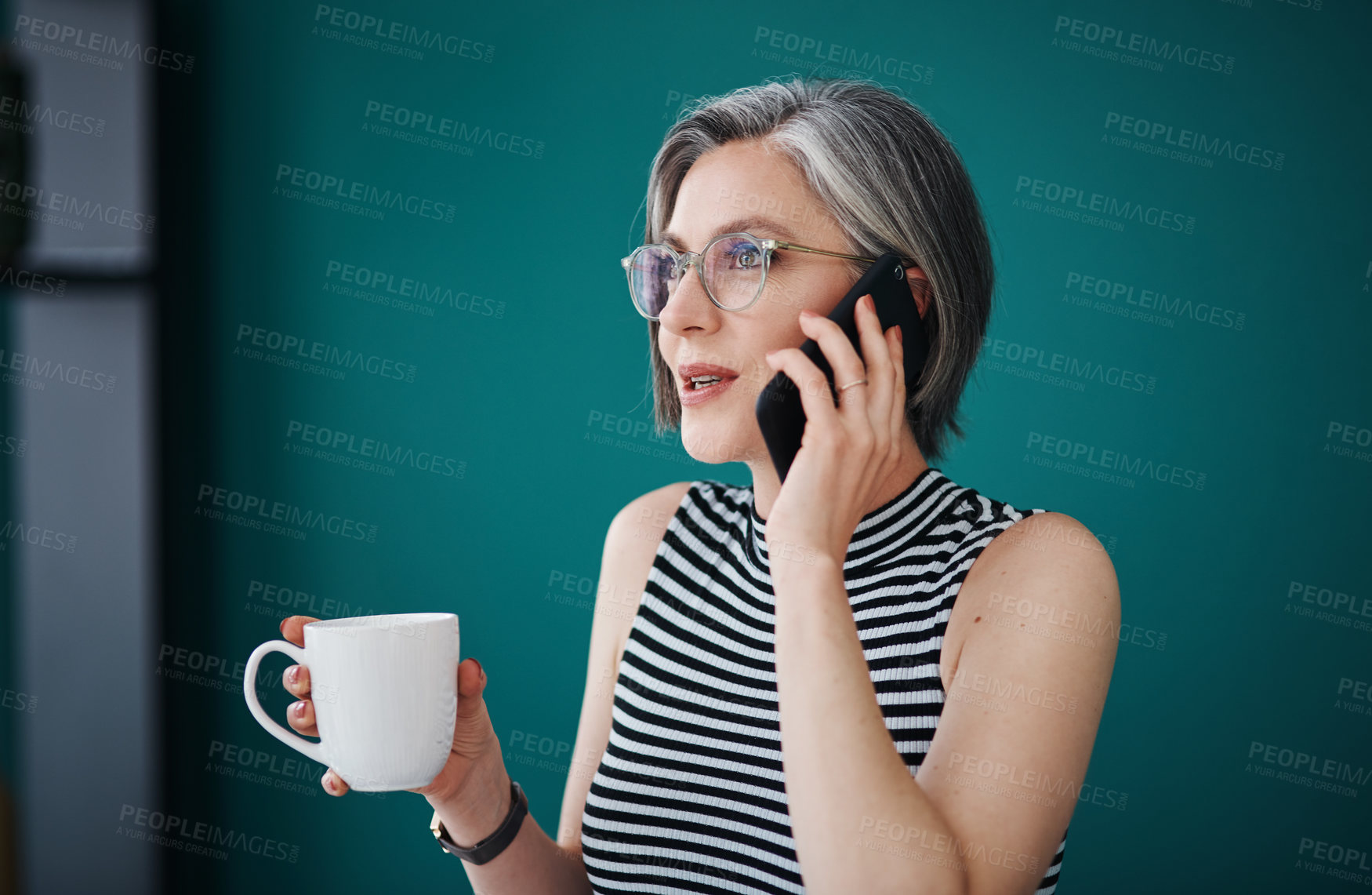 Buy stock photo Shot of a businesswoman having coffee while talking on her cellphone in her office