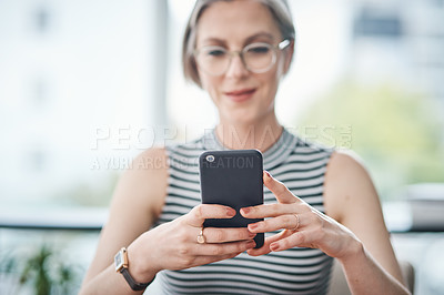 Buy stock photo Cropped shot of a mature businesswoman using her cellphone in her office