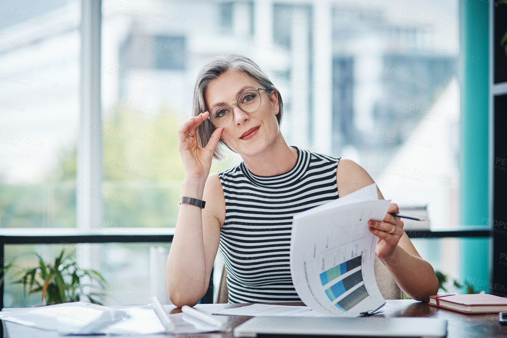 Buy stock photo Shot of of a mature businesswoman working on paperwork in her office`