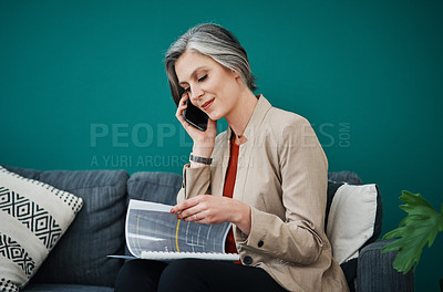 Buy stock photo Cropped shot of an attractive mature businesswoman sitting alone and using her cellphone while reading paperwork in her home office