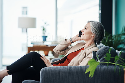 Buy stock photo Cropped shot of an attractive mature businesswoman sitting alone and talking on her cellphone in her home office