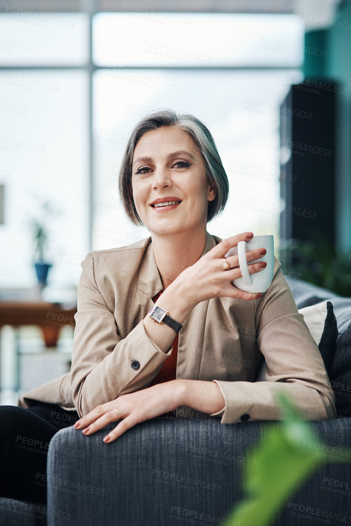 Buy stock photo Cropped portrait of an attractive mature businesswoman sitting alone and enjoying a cup of coffee in her home office