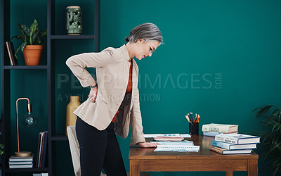 Buy stock photo Cropped shot of an attractive mature businesswoman standing and suffering from backache while in her home office