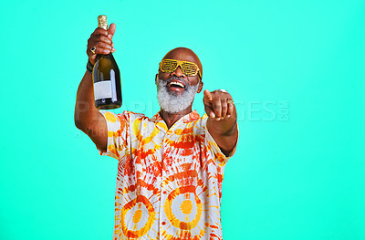 Buy stock photo Mature man, champagne and celebration in studio for birthday party, happiness and festival even. Black person, alcohol and cool sunglasses for holiday, pointing or New Year concert on blue background