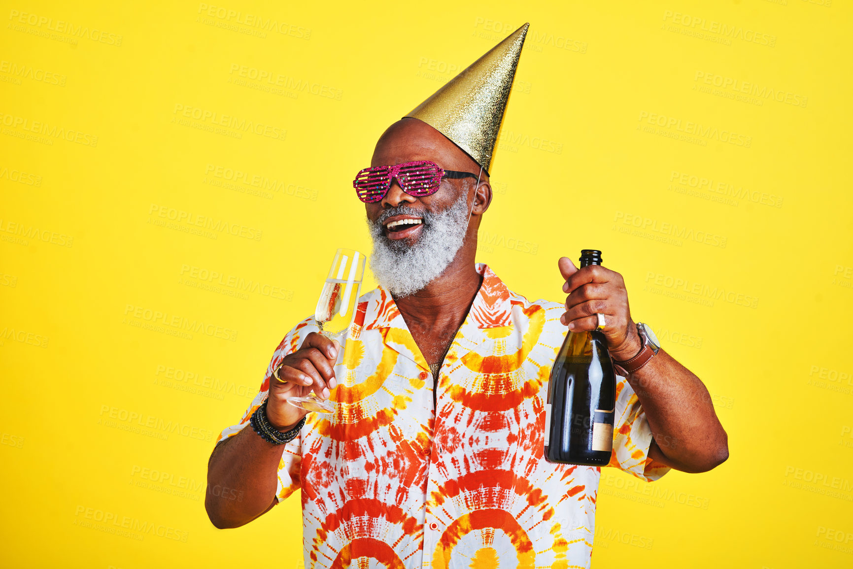 Buy stock photo Cropped shot of a funky and cheerful senior man celebrating and drinking champagne in studio against a yellow background