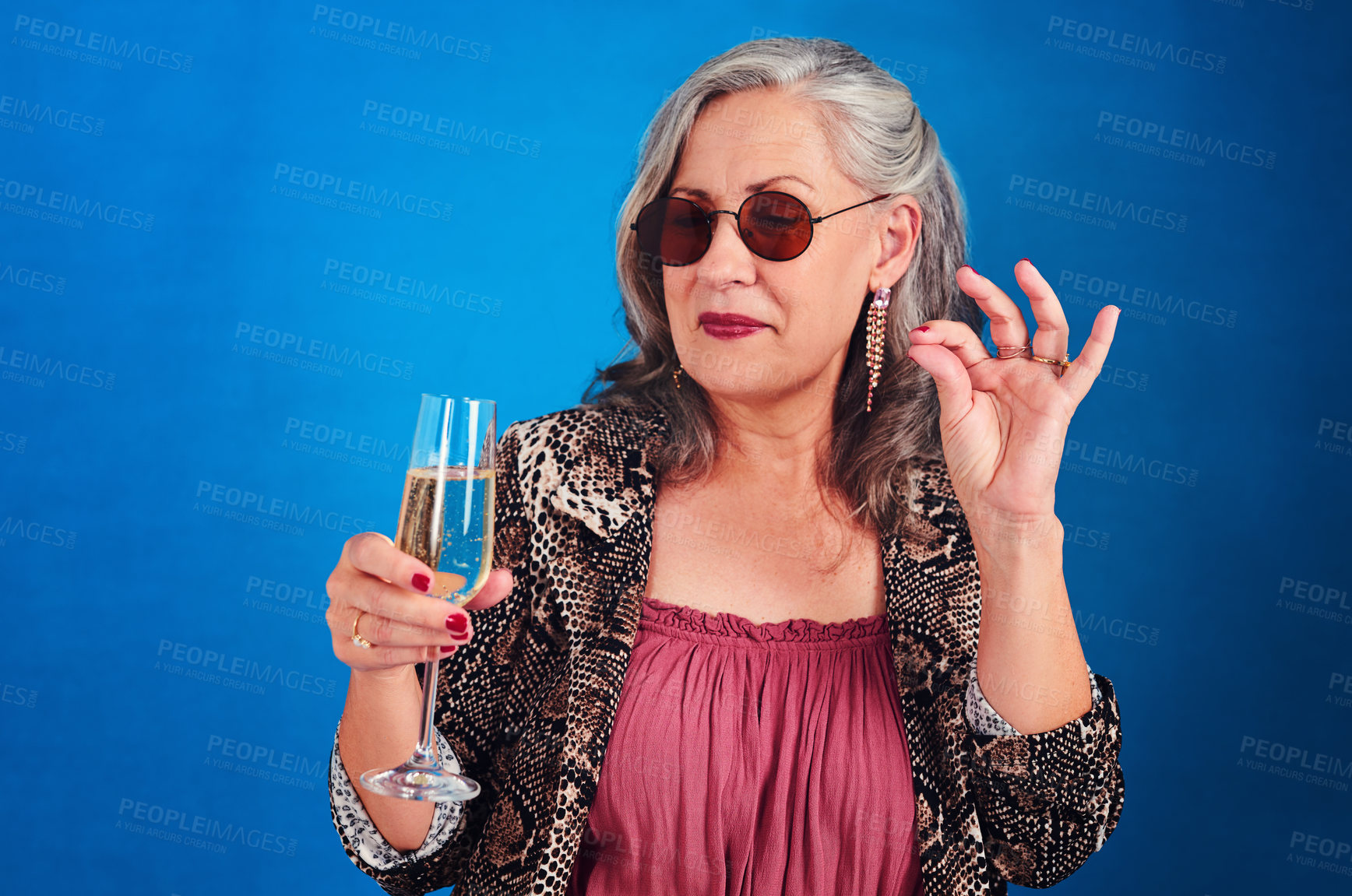 Buy stock photo Cropped shot of a funky and cheerful senior woman drinking a glass of champagne in studio