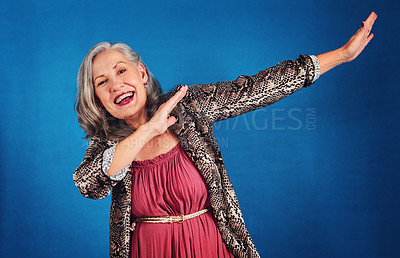 Buy stock photo Portrait of a funky and cheerful senior woman dancing in studio against a blue background