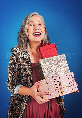 Buy stock photo Portrait of a cheerful senior woman holding boxes of gifts and presents in studio