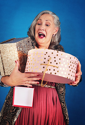 Buy stock photo Cropped shot of a cheerful senior woman holding boxes of gifts and presents in studio