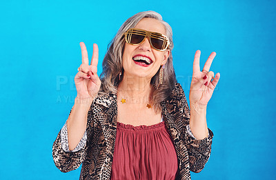 Buy stock photo Portrait of a funky and stylish senior woman posing in studio against a blue background