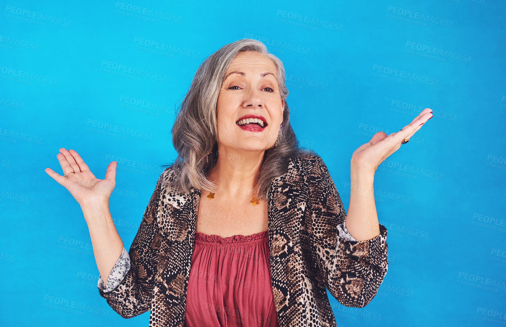 Buy stock photo Portrait of a funky and stylish senior woman posing in studio against a blue background