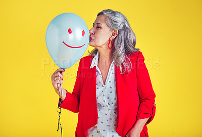 Buy stock photo Cropped shot of a funky and stylish senior woman kissing a balloon against a yellow background