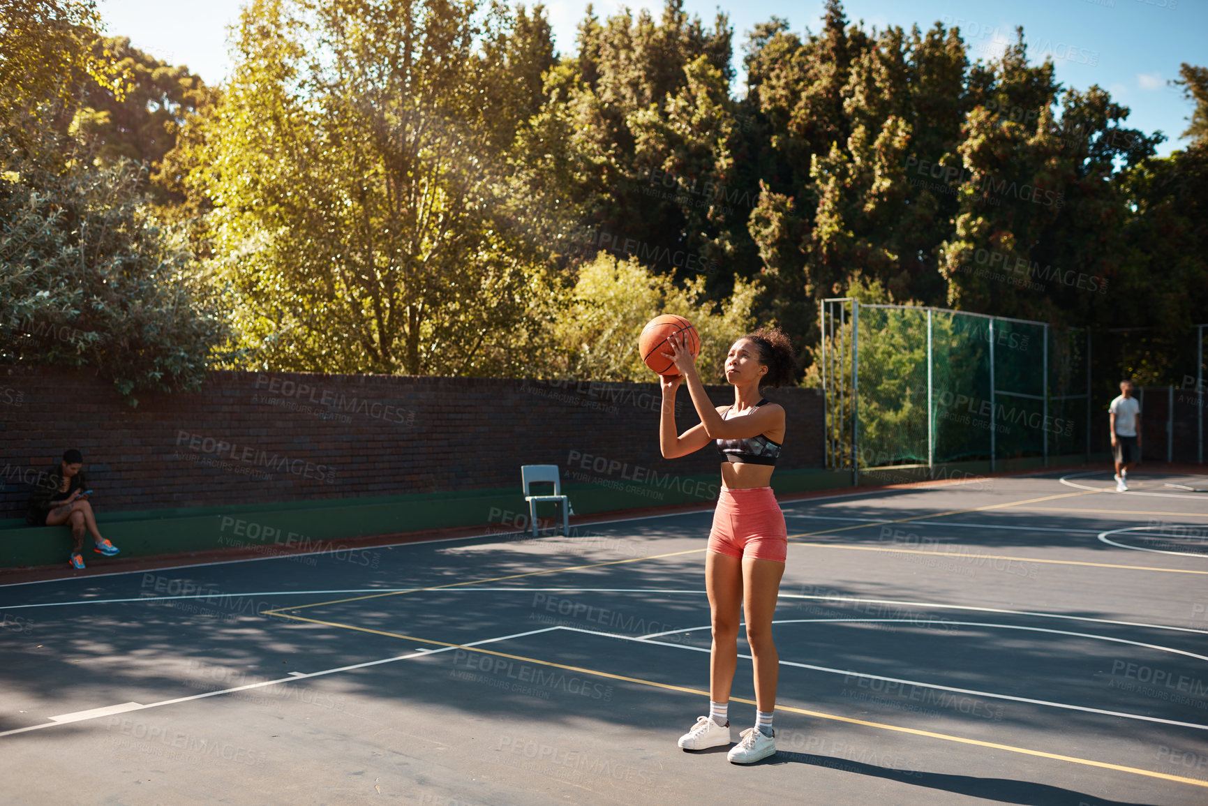 Buy stock photo Shot of a sporty young woman playing basketball on a sports court