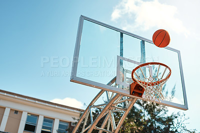 Buy stock photo Still life shot of a basketball landing into a net on a sports court