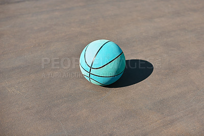Buy stock photo Still life shot of a basketball on the ground in a sports court