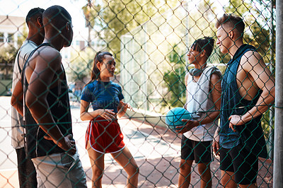 Buy stock photo Shot of a group of sporty young people chatting on a sports court