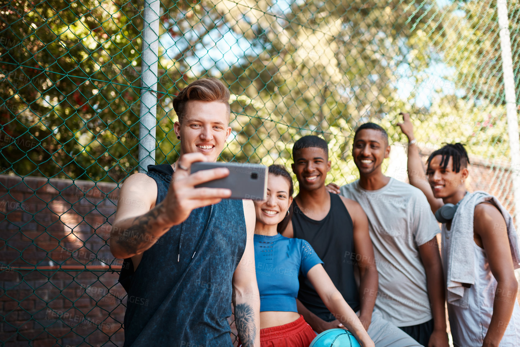 Buy stock photo Shot of a group of sporty young people taking selfies together outdoors
