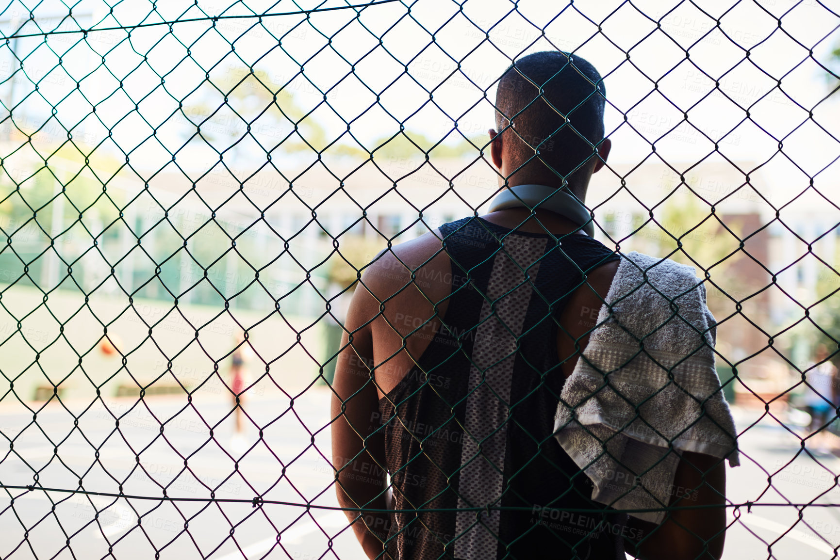 Buy stock photo Back, basketball and fence with man on court for break from exercise, fitness or training outdoor. Rest, sports and towel with athlete player at venue for competition, challenge or performance