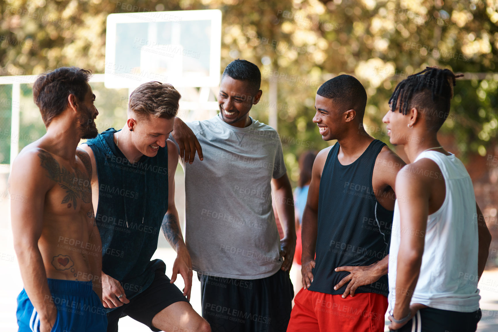 Buy stock photo Shot of a group of sporty young men standing on a basketball court