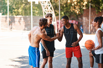 Buy stock photo Shot of a group of sporty young men greeting each other on a basketball court